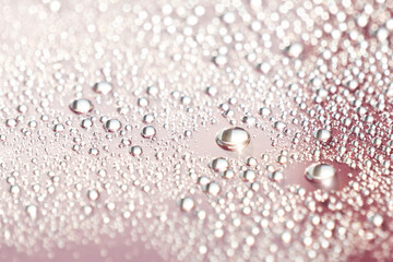 Fototapeta premium Abstract cosmetic background of a drop of moisturizing liquid on a pink background. Moisturizer tonic, lotion, serum.