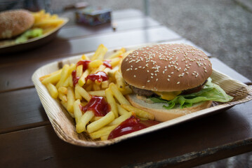 Closeup of hamburger and french fries at the fast food restaurant terrace