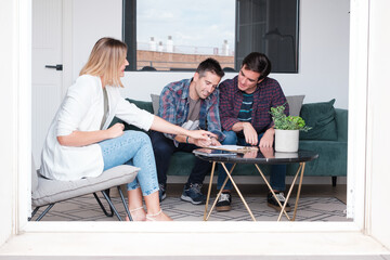 Young lgtbi couple signing the contract to live in their new house. Concept: move, pride, signature