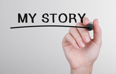 Womans hand writing word My story with marker