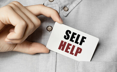 Man putting a card with text self help in the pocket