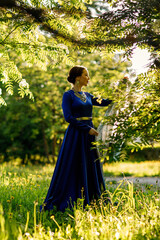 a girl in a blue dress in a spring forest