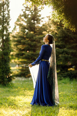 Obraz na płótnie Canvas a girl in a blue dress in a spring forest