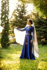 a girl in a blue dress in a spring forest