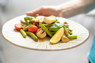 plate with asparagus salad, tomato, fish and lemon