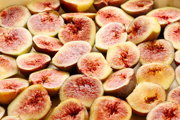 Low angle view of many half sliced fresh, organic fig fruits, placed on a baking paper. Abstract food background. Selective focus and shallow depth of field - Powered by Adobe