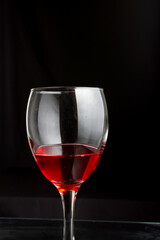 A glass of red wine on a black background