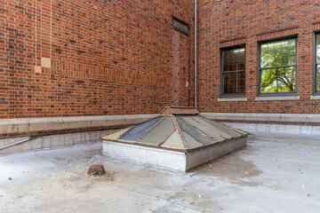 Old, vintage metal framed double pitched skylight on a flat commercial, industrial, or school...