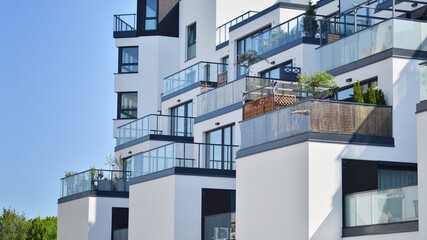 Apartment building with bright facades. Modern minimalist architecture with lots of square glass windows and balconies.