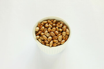Carioca beans in a bowl. Brazilian beans isolated in a white background.