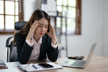 Tired asian business woman overworking and  headache stressed in office.