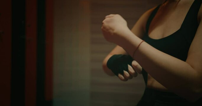 woman wrapping hands by tape before workout in self-defense class, closeup view of hands, 4K, Prores
