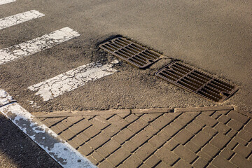 sewer grate in the asphalt, metal drain on the street,