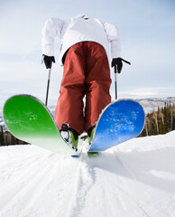 Rear view of mid-adult male on skis in Steamboat, Colorado.