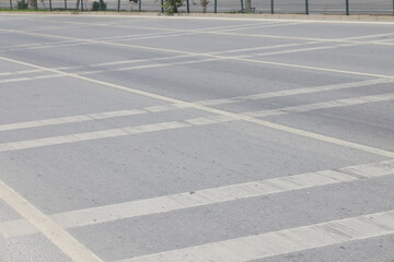 A street border painted in white and black on the background of the road and green foliage in the...