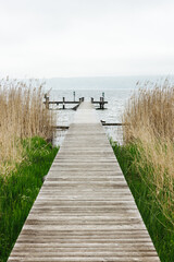 Fototapeta premium Serene wooden landing stage on a cloudy day at the Ammersee Lake in Bavaria, southern Germany
