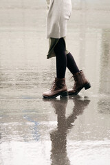 雨の中を歩く女性の足元のクローズアップ