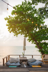 Romantic sunset on the shore of a tropical island, Koh Chang, Thailand. Outdoor cafe on the beach..Beach cafe and restaurant with scenic ocean view..Summer vacation or holiday, family travel.