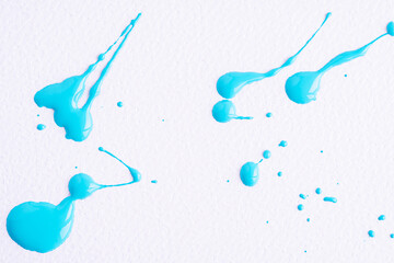 Watercolor blue drop splash. Splattered of blue ink drops on white paper background. Sample of cosmetics. The puddle of an oil paint spill