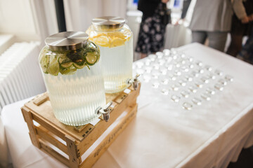 Jars filled with water and lemon slices at a wedding buffet