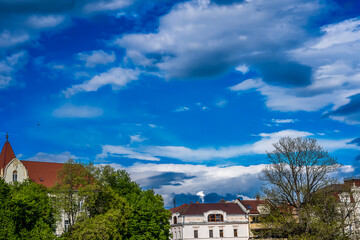 blue sky background with clouds over trees in the city