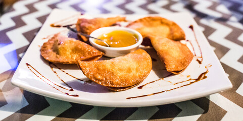 a plate of pastries with sauce in the center