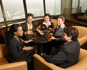 Ethnically diverse businesspeople sitting at table in restaurant talking.
