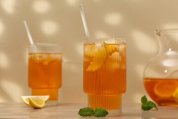 Iced tea with lemon and mint in a glass and in a jug. Summer drinks.