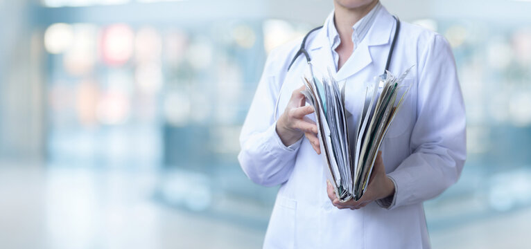 A medical worker opens a folder with case histories.