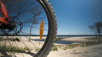 close-up of the front wheel of a bicycle against the background of the sea
