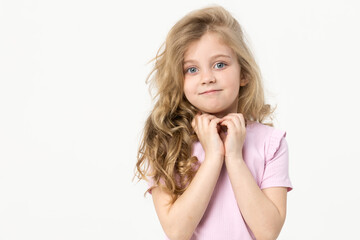 Portrait of a cute baby girl on a white background, holding her hands near her face. Big blue eyes and wavy hair. Blank space for inscription