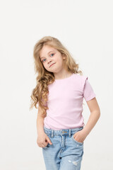 Obraz premium Portrait of a cute baby girl on a white background, holding her hands near her face. Big blue eyes and wavy hair. Blank space for inscription
