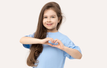 Portrait of positive child girl showing heart sign smiling isolated white background.