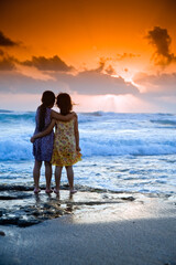 two girls in the beach at sunset