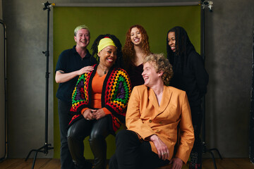 Obraz na płótnie Canvas Portrait of five LGBTQIA queer people laughing against studio backdrop gay pride