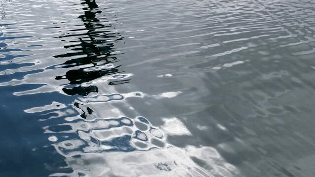 reflection in clean clear water gray color sun light rays of daylight lantern or pillar ripples on sea