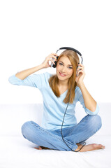 Young woman sitting on couch and listen to the music