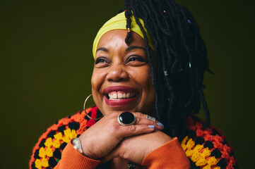 Portrait of lesbian woman smiling with hands on chin against studio backdrop pride month