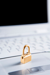 Golden lock on the laptop, focus mainly on the front side of the lock.