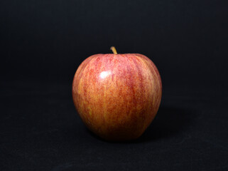 Red and yellow apples on a black background. Delicious apples close-up.