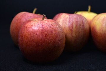 Red and yellow apples on a black background. Delicious apples close-up.