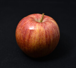 Red and yellow apples on a black background. Delicious apples close-up.