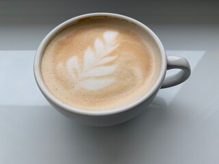 Cappuccino coffee in a beautiful glass on the table. Concept: favorite cup of coffee with milk. Latte in a coffee cup, nicely decorated.