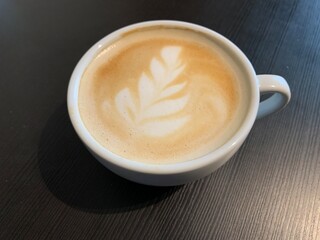 Cappuccino coffee in a beautiful glass on the table. Concept: favorite cup of coffee with milk. Latte in a coffee cup, nicely decorated.