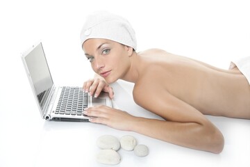 Beautiful woman in spa working with laptop computer