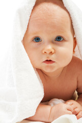 Lovely baby lying under white towel, isolated
