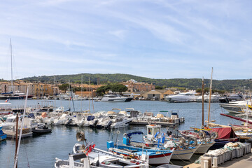 Fototapeta na wymiar Marina with yachts and shipping boats and promenade in Saint Tropez, Cote d'Azur, French Riviera