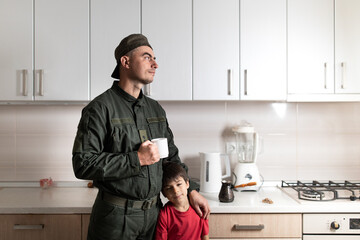 Military man in olive uniform and cap with his little son after long parting at home