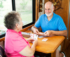 Senior couple vacationing in their motor home, playing a game of cribbage.