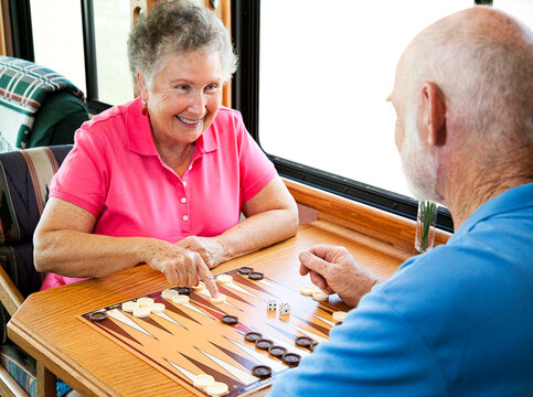 Senior couple enjoys a game of backgammon in their motor home.